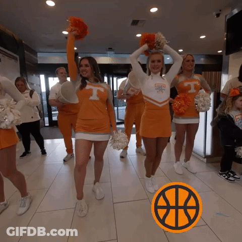 Cheerleaders In Orange Uniforms With The Letter T On Their Shirts GIF