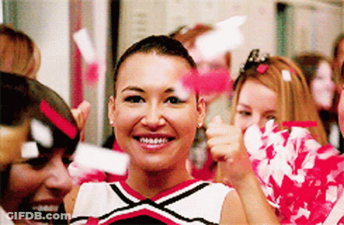 Cheerleaders Smiling With Pom Poms In Locker Room GIF