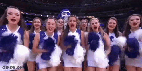 Cheerleaders Standing In Front Of Mascot GIF