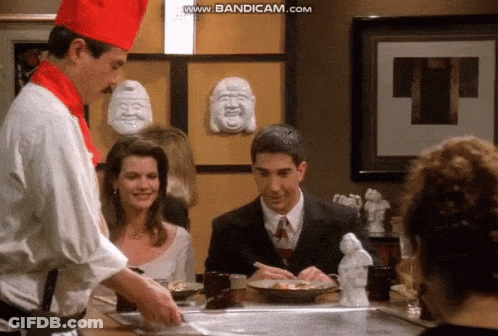 Chef-Hatted Man Cooking For Woman And Suited Man GIF