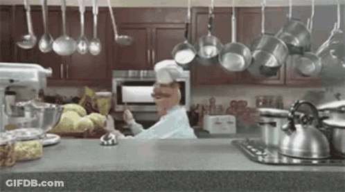 Chef In Kitchen With Hanging Pots And Pans GIF