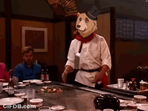 Chef In Top Hat With Bear Head At Table GIF