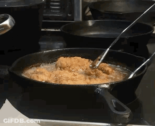 Chicken Is Being Cooked In A Frying Pan On A Stove GIF