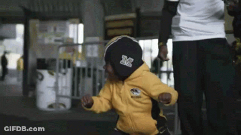 Child In Yellow Jacket With Letter M GIF
