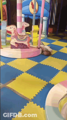 Child Lying On Playground Floor GIF