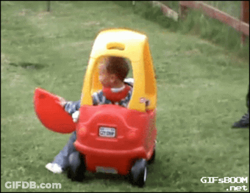 Child Sitting In Red And Yellow Toy Car GIF