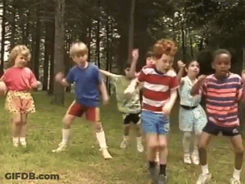Children Dancing In Grass Near Trees GIF