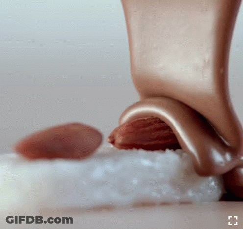 Chocolate Being Poured On Almond GIF