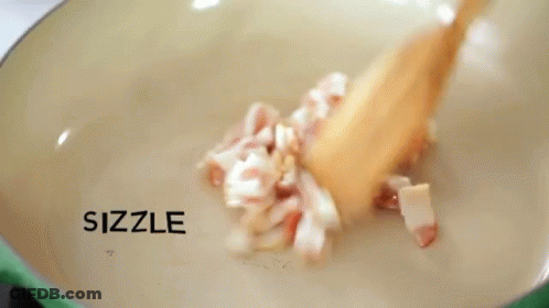 Chopped Bacon Is Being Stirred In A Pan With The Words Sizzle And Sizzle Written On The Bottom GIF
