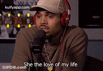 Chris Brown Is Wearing Headphones And A Hat While Talking Into A Microphone . GIF