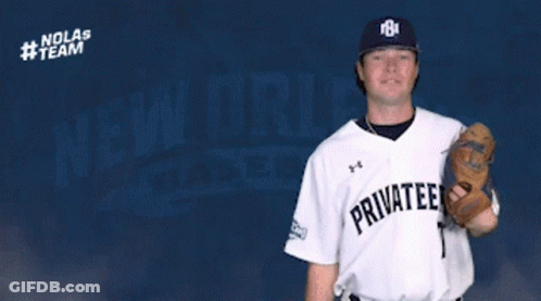 Chris Turpin Throws Baseball In Front Of Nolas Team Logo GIF