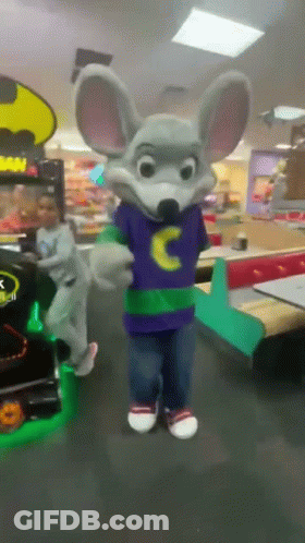 Chuck E Cheese Mascot In A Purple Shirt With A Yellow C On It GIF