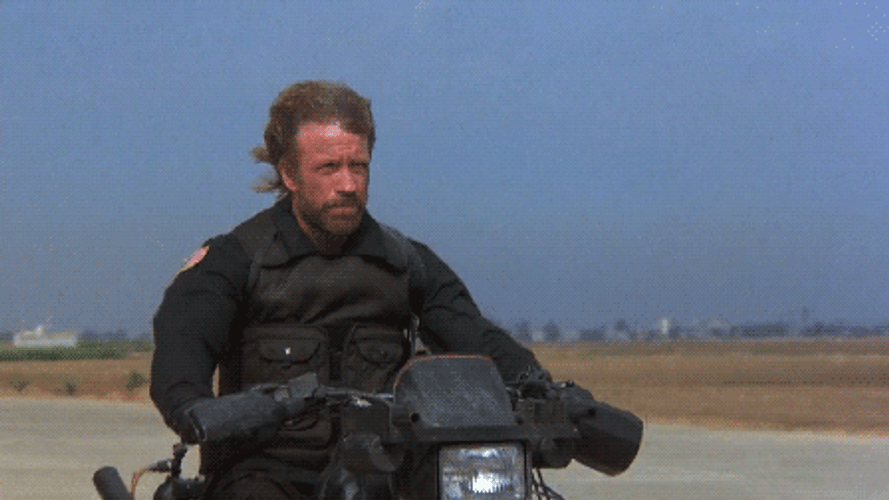 Chuck Norris Firing Guns Through Motorcycle GIF
