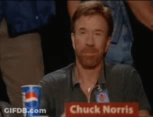 Chuck Norris Is Sitting At A Table With A Sign That Says Chuck Norris GIF