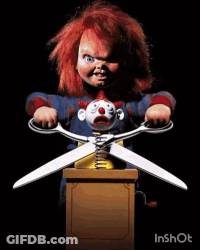 Chucky Holding Scissors Over Clown Doll GIF
