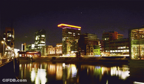 City At Night With River And Yellow Light On Building GIF
