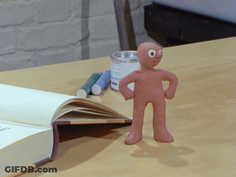 Clay Figure Standing Next To Book GIF