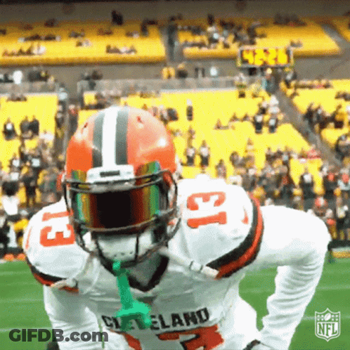 Cleveland Football Player Holding Green Object In Mouth GIF