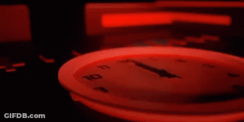 Close Up Clock With Red Light Around Face GIF