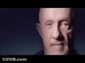 Close Up Man With Beard Looking At Camera In Dark Room GIF