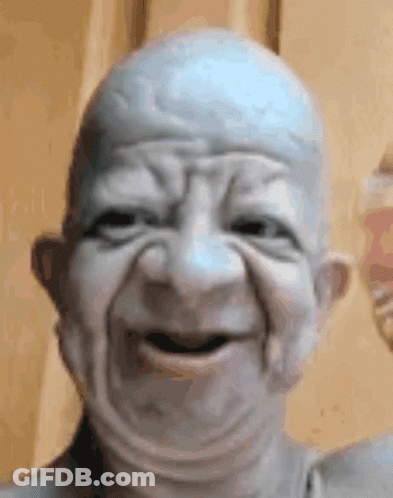 Close Up Of Bald Old Man Statue Making Face GIF
