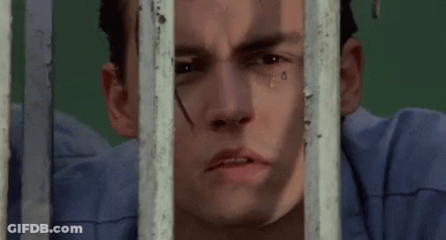 Close Up Of Man Behind Bars With Tear Running Down Face GIF