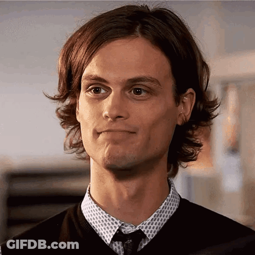 Close Up Of Man In Sweater And Tie Making Funny Face GIF