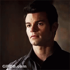 Close Up Of Man's Face In Black Shirt And Vest GIF