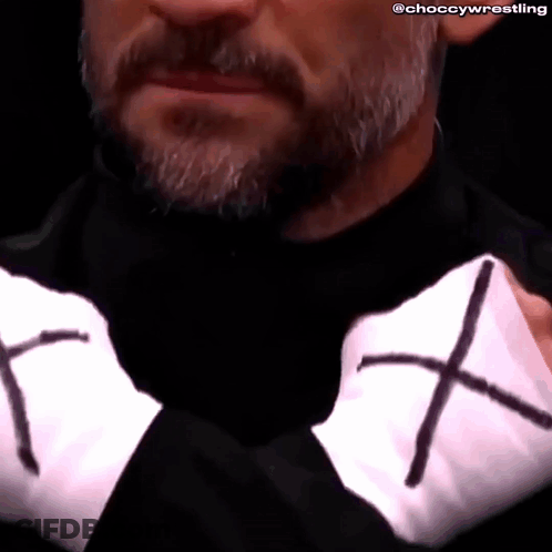 Close Up Of Man's Face With Beard And Black Shirt With Cross GIF