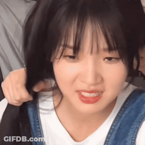 Close Up Of Person Holding Hair And Making Funny Face GIF