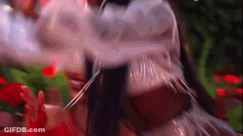 Close Up Of Person's Face With Blurred Flowers And Trees GIF