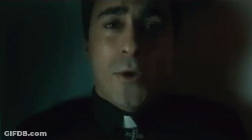 Close Up Of Priest's Face With Cross GIF