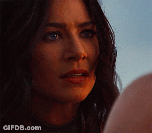 Close Up Of Woman's Face With Dark Hair And Blue Eyes GIF