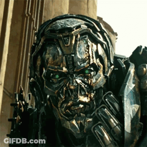 Close Up Robot With Green Eyes In Front Of Building GIF