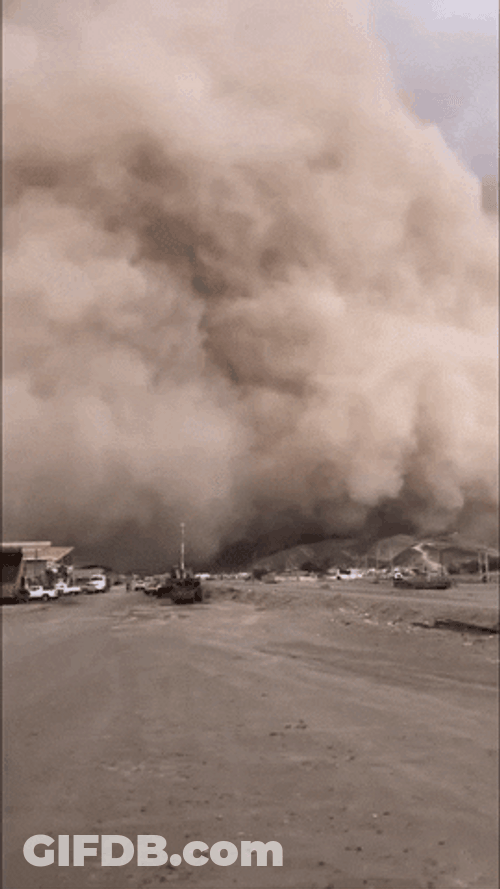 Cloudy Dust Storm Moving Through Houses GIF