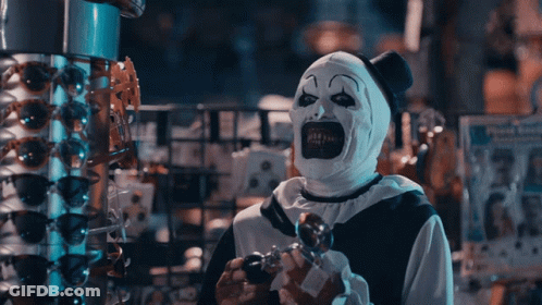 Clown In White And Black Costume Holding Something GIF