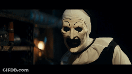 Clown In White Mask With Black Mouth Looking At Camera GIF