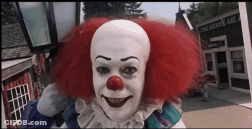 Clown Smiling In Front Of Building That Says The News GIF