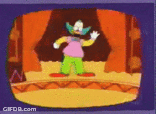Clown Standing On Stage In Front Of Orange Curtain GIF