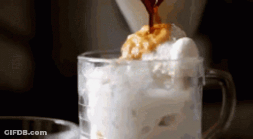 Coffee Is Being Poured Into A Glass Of Ice Cream And Whipped Cream . GIF