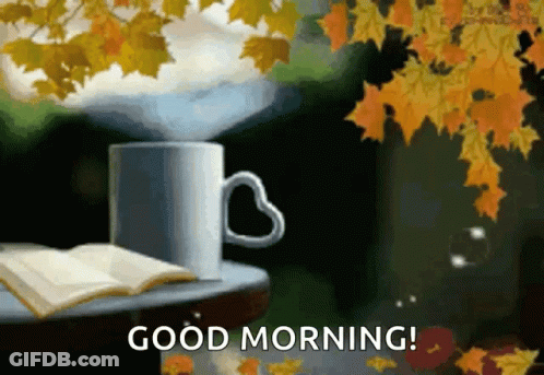 Coffee With Heart Handle Beside Open Book And Leaves GIF