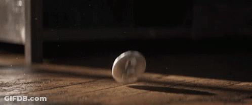 Coin Falling On Wooden Floor In Dark Room GIF