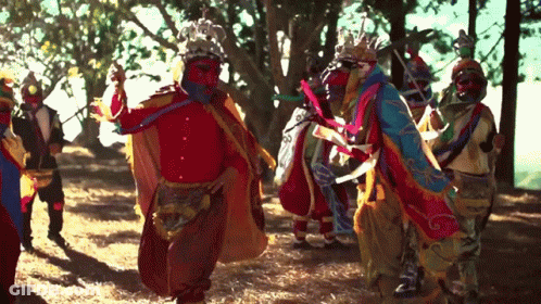Colorful Costumes Dancing In Forest GIF