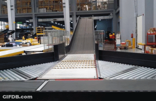 Conveyor Belt Going Down Ramp In Factory GIF