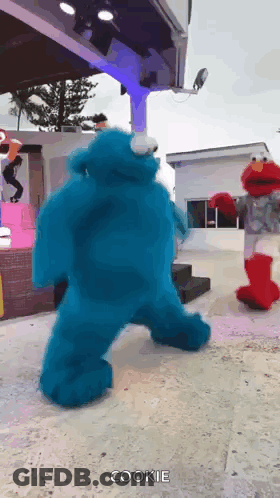 Cookie Monster And Elmo Dancing On Stage GIF
