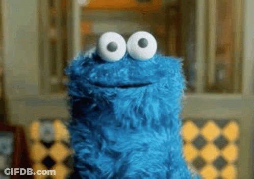 Cookie Monster From Sesame Street Is Smiling And Looking At The Camera With Big White Eyes . GIF