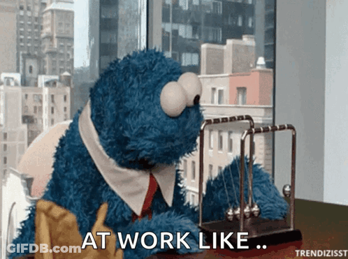 Cookie Monster Sitting At Desk With Newton's Cradle GIF