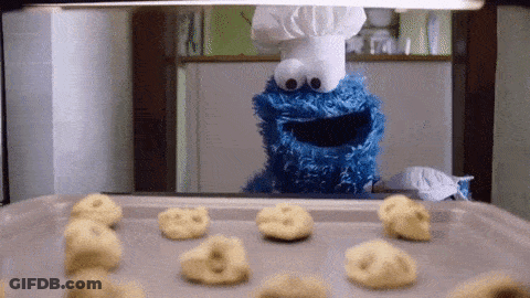 Cookie Monster Wearing A Chef 'S Hat Is Looking At Cookies On A Pan GIF