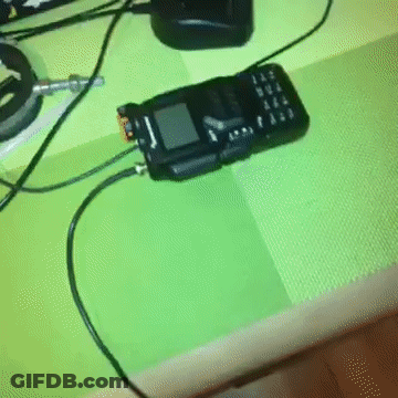 Corded Cell Phone On Green Table GIF