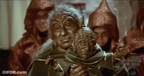 Costumed Group Around Statue Of Man Holding Man GIF